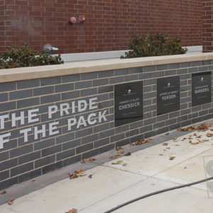 engraved granite plaques with raied letters mounted to stone pillar