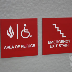 red ada area of refuge signs with raised white copy and clear braille rastors