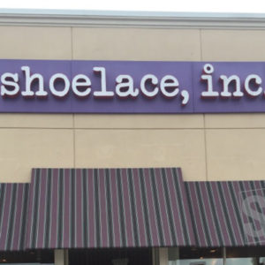 shoelace, inc - day - channel letters on a purple pan sign