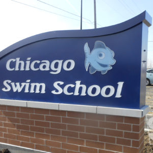 swim school inspired mounument sign to match the ocean with routed push through letters and custom digital print